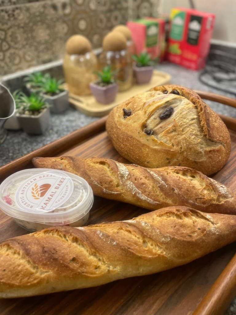 Kamal Bake baguettes and sourdough on a wooden tray with Kamal Bake label