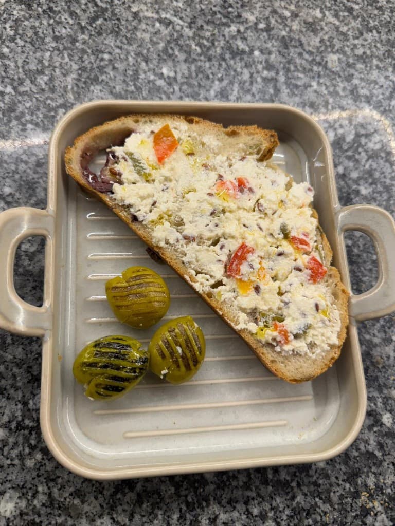 Toasted sourdough with creamy vegetable spread and grilled olives